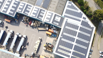 A large industrial building with multiple solar panels installed on the roof at Caps Cases, Newmarket A large industrial building with multiple solar panels installed on the roof at Caps Cases, Newmarket