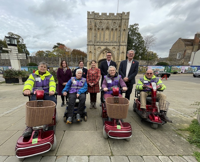 Shopmobility in Bury St Edmunds will be run by EcoCarriers from 3 November 2025 ecoCarriers Sharon Steven, Rowan Wilson, Libby Ranzetta and David Fisher with some of the vehicles,Sue Warren from Our Bury St Edmunds and Bury St Edmunds and Beyond, Cllr Diane Hind from the town council, Cllr Donna Higgins, Allan Hassell from the arc and Cllr Cliff Waterman on Angel Hill, Bury St Edmunds
